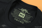 A photograph of the printed tag information on a unisex medium Stray t-shirt: 100% cotton, no dry clean, machine wash cold, shirt made in Guatemala, tumble dry, low heat. Designed for BlueTwelve Studio by fangamer. Thumbnail